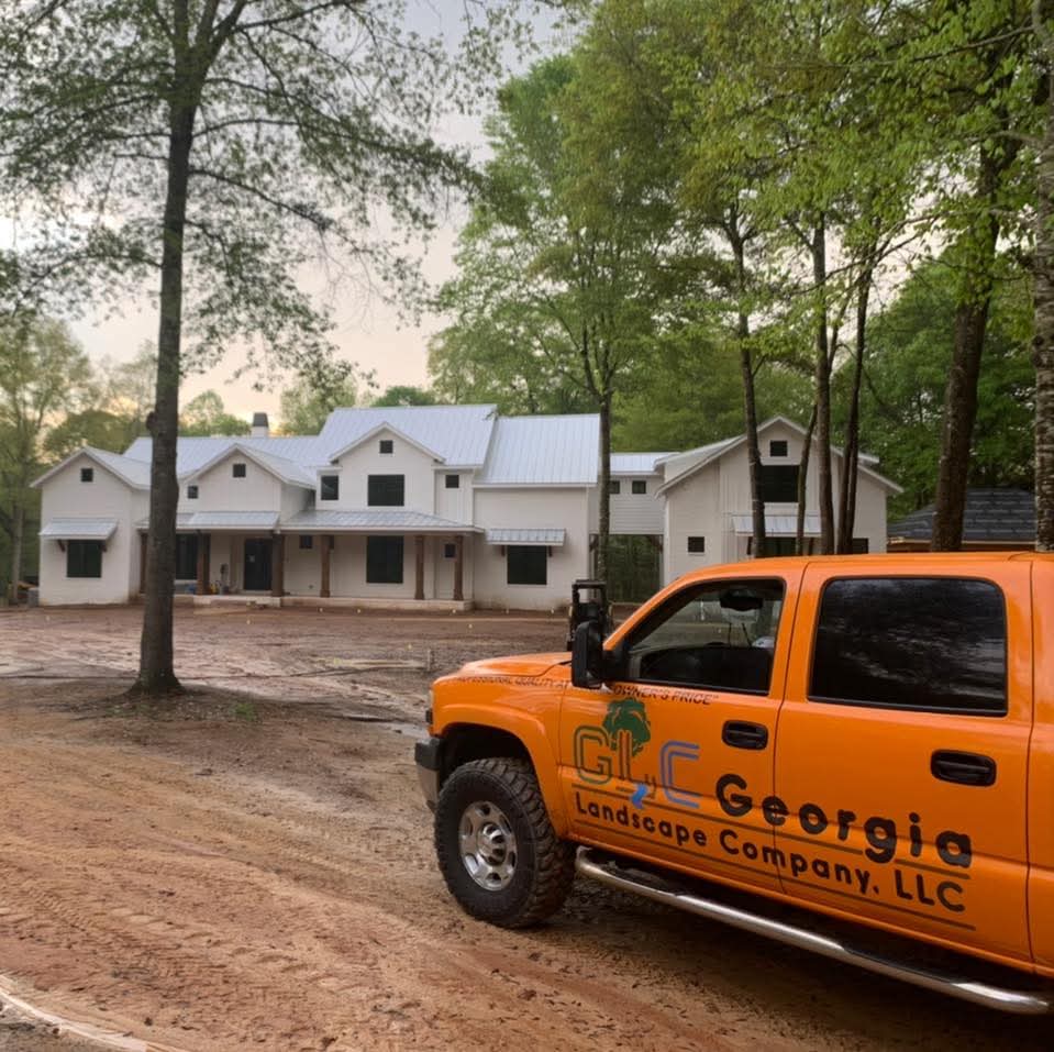 Orange GLC pickup in front of a new white farmhouse build
